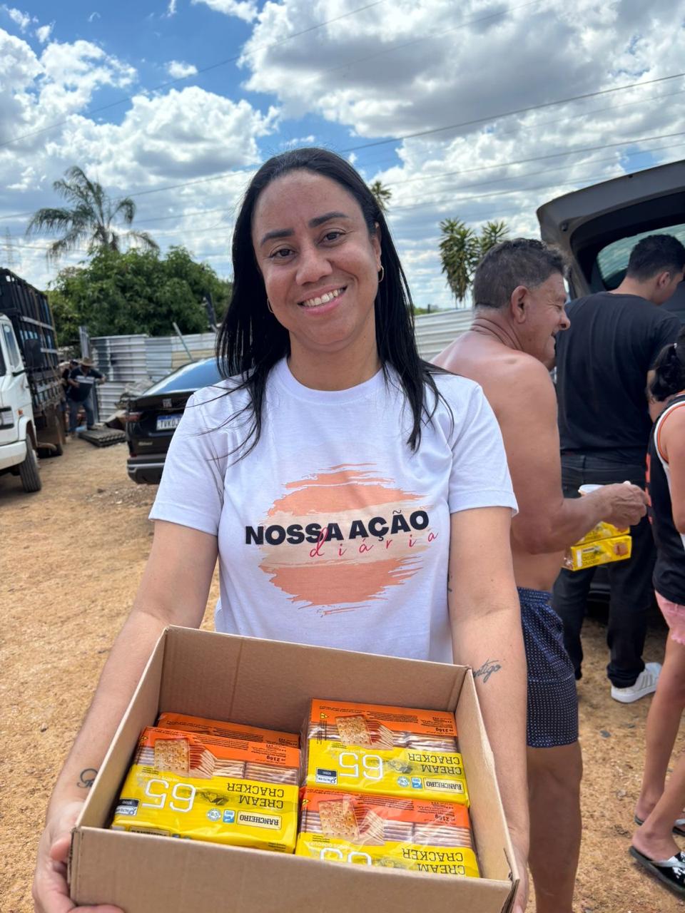Voluntária da Associação Nossa Ação Diária distribuindo caixas de alimentos para famílias em Brasília