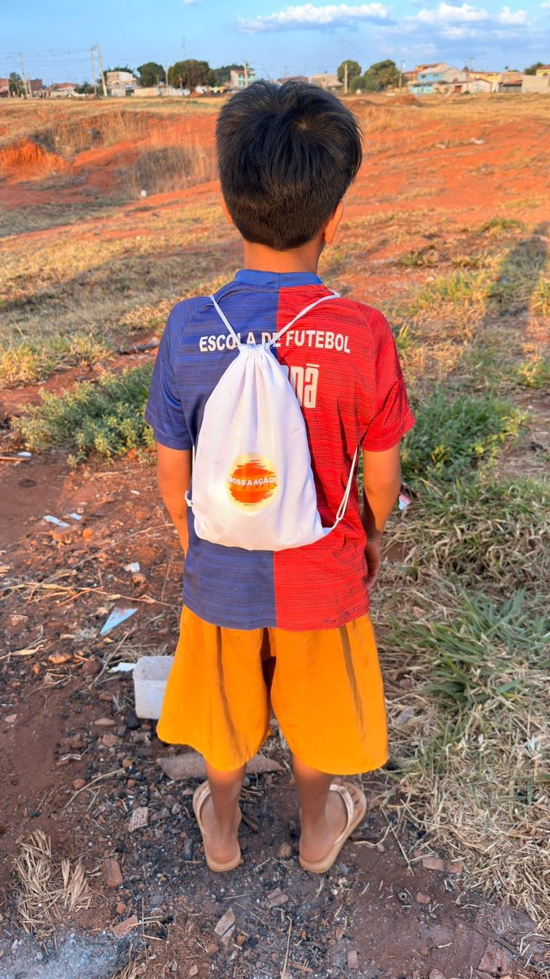 Menino de costas com mochila da Nossa Ação Diária