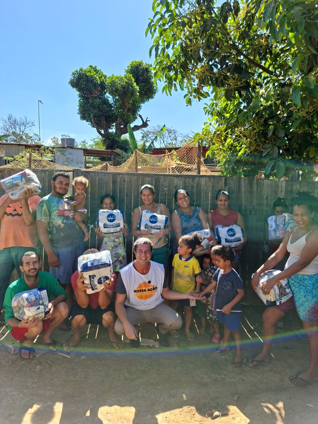 Famílias segurando kits de doação