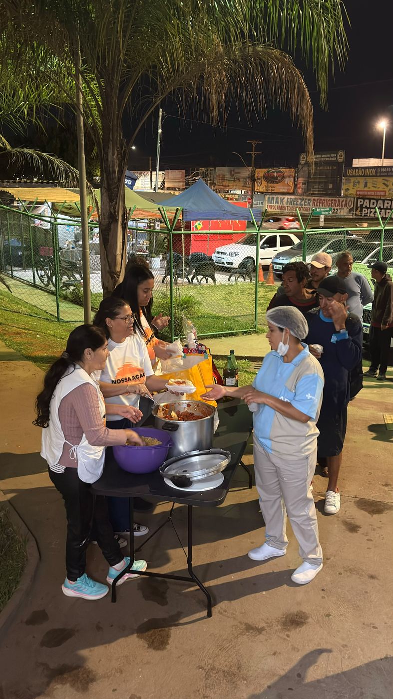 Mesa de distribuição de comida em praça à noite