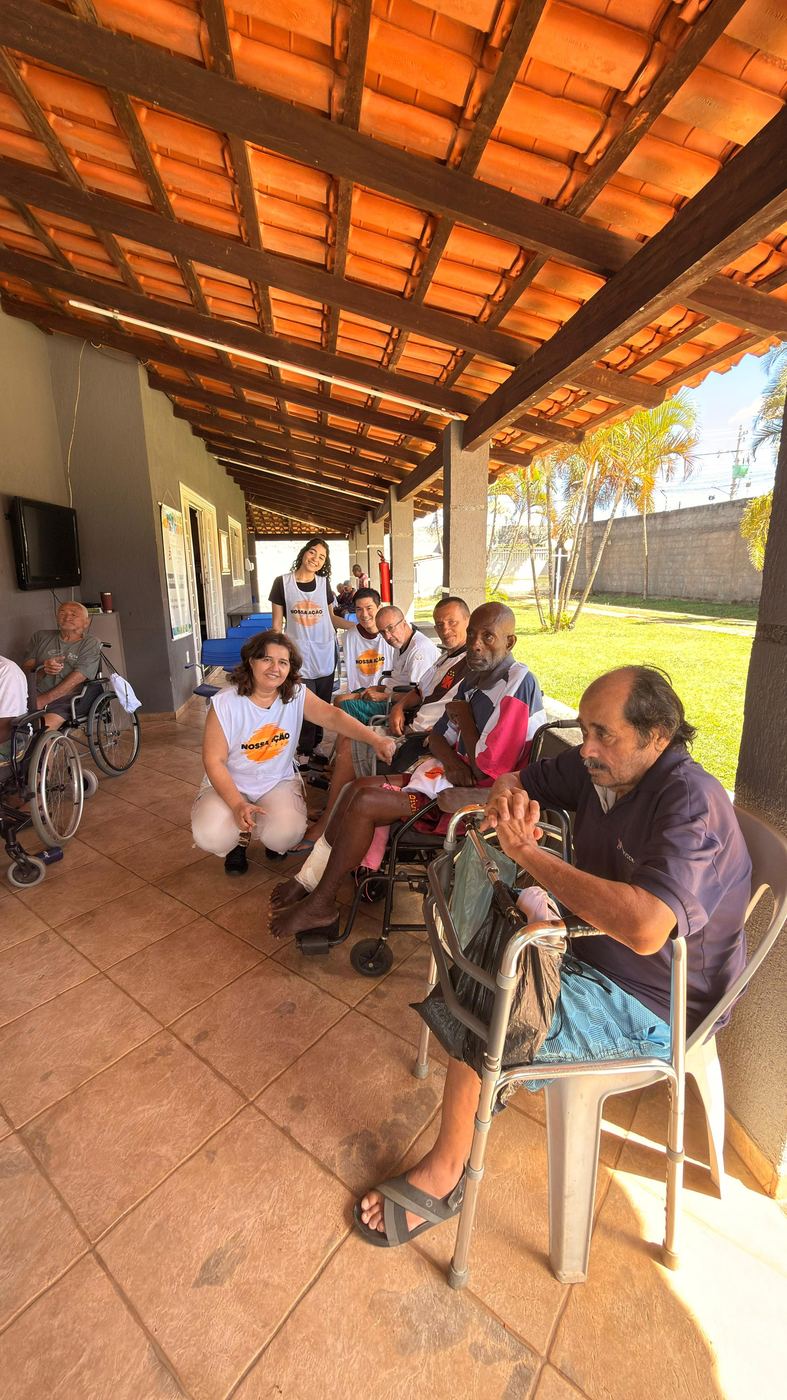 Voluntários conversando com idosos numa varanda