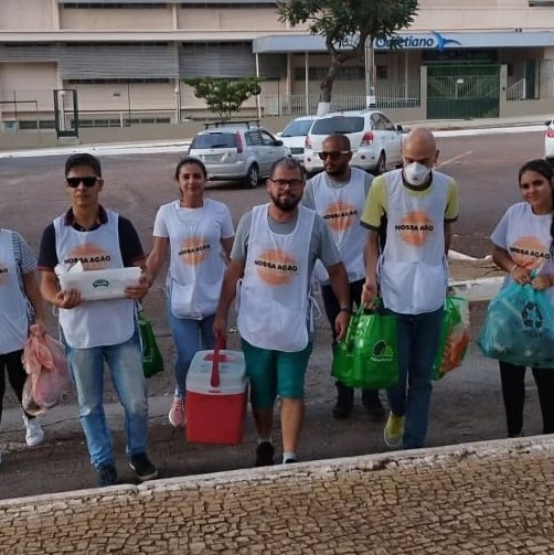 Equipe de voluntários de colete da Nossa Ação, saindo para a entrega